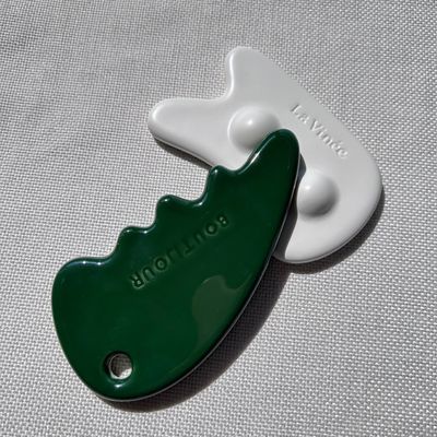Gesichtsmassager Gua Sha Stein in grüner Farbe für Selbstpflege und Schönheitssalon